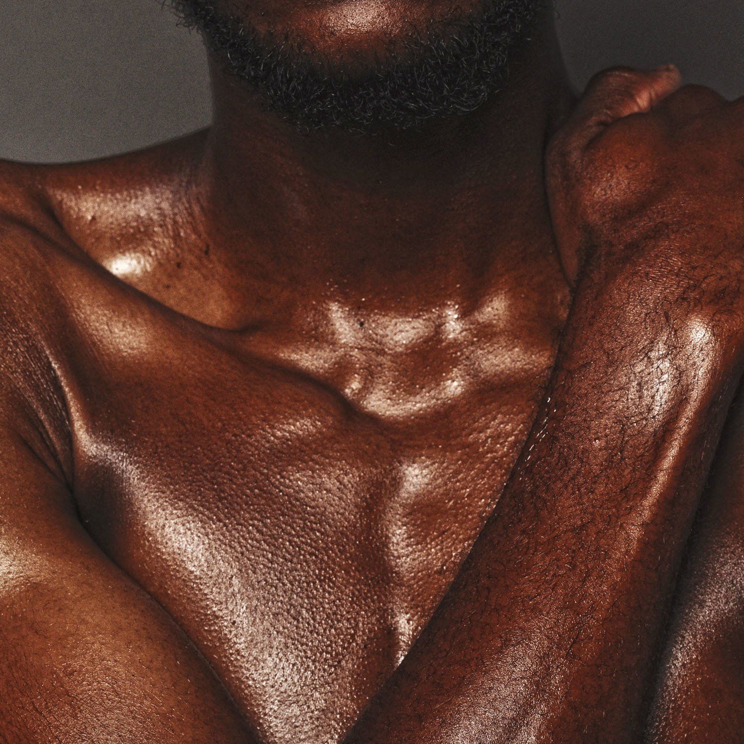 A close up of a man 's chest with his arms crossed