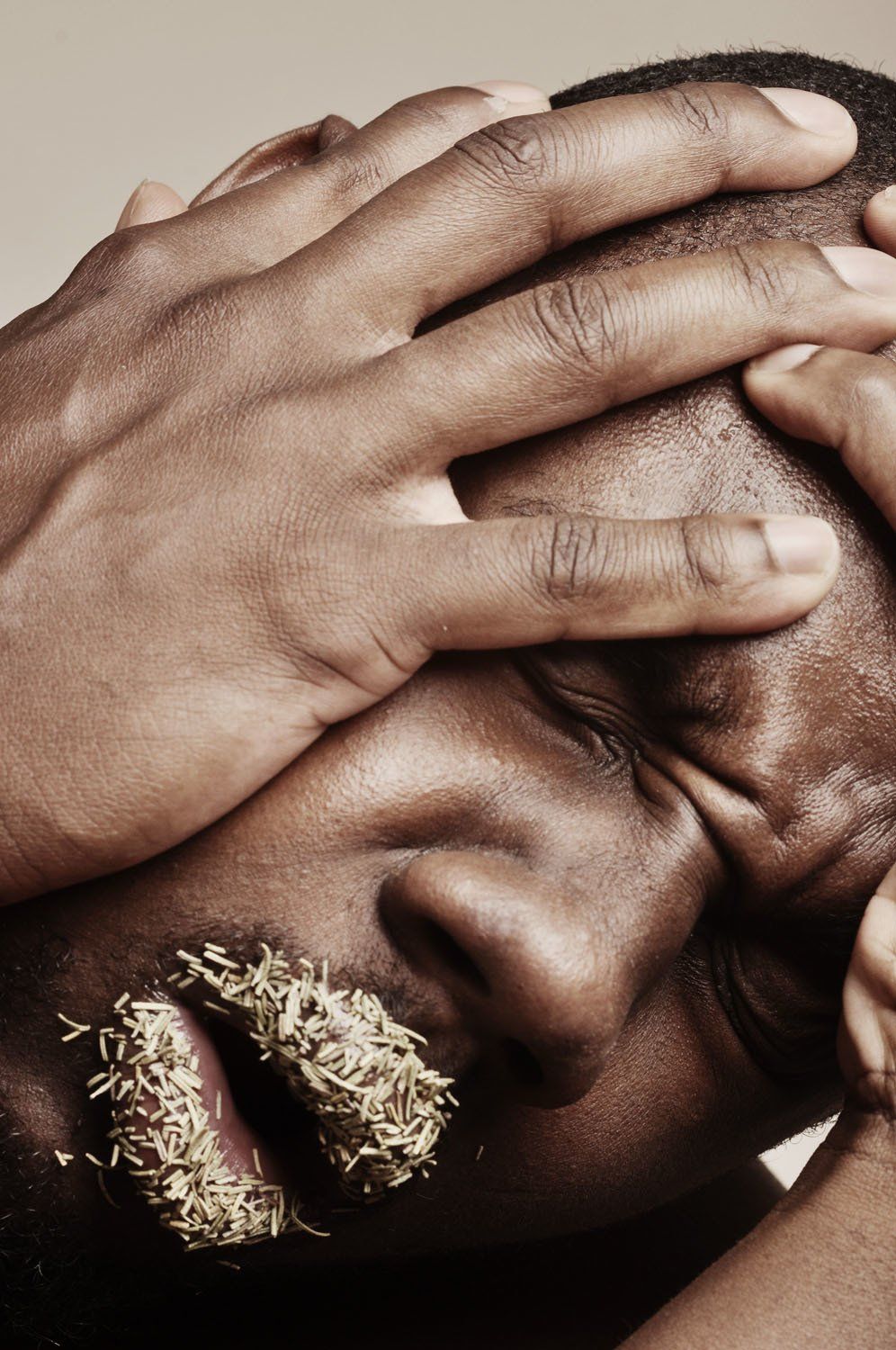 A close up of a man covering his face with his hands
