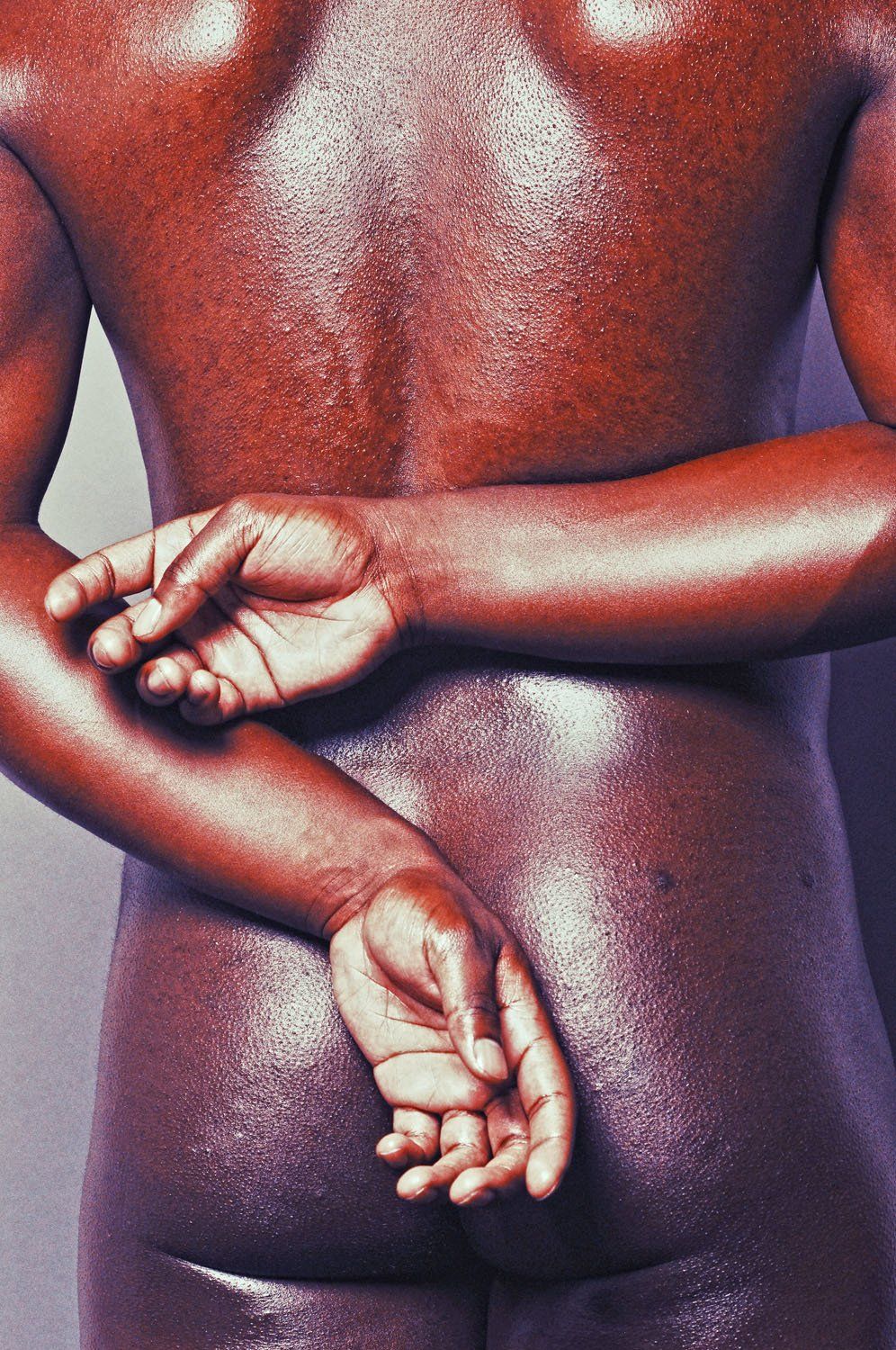 A close up picture of a person with their arms behind their back.