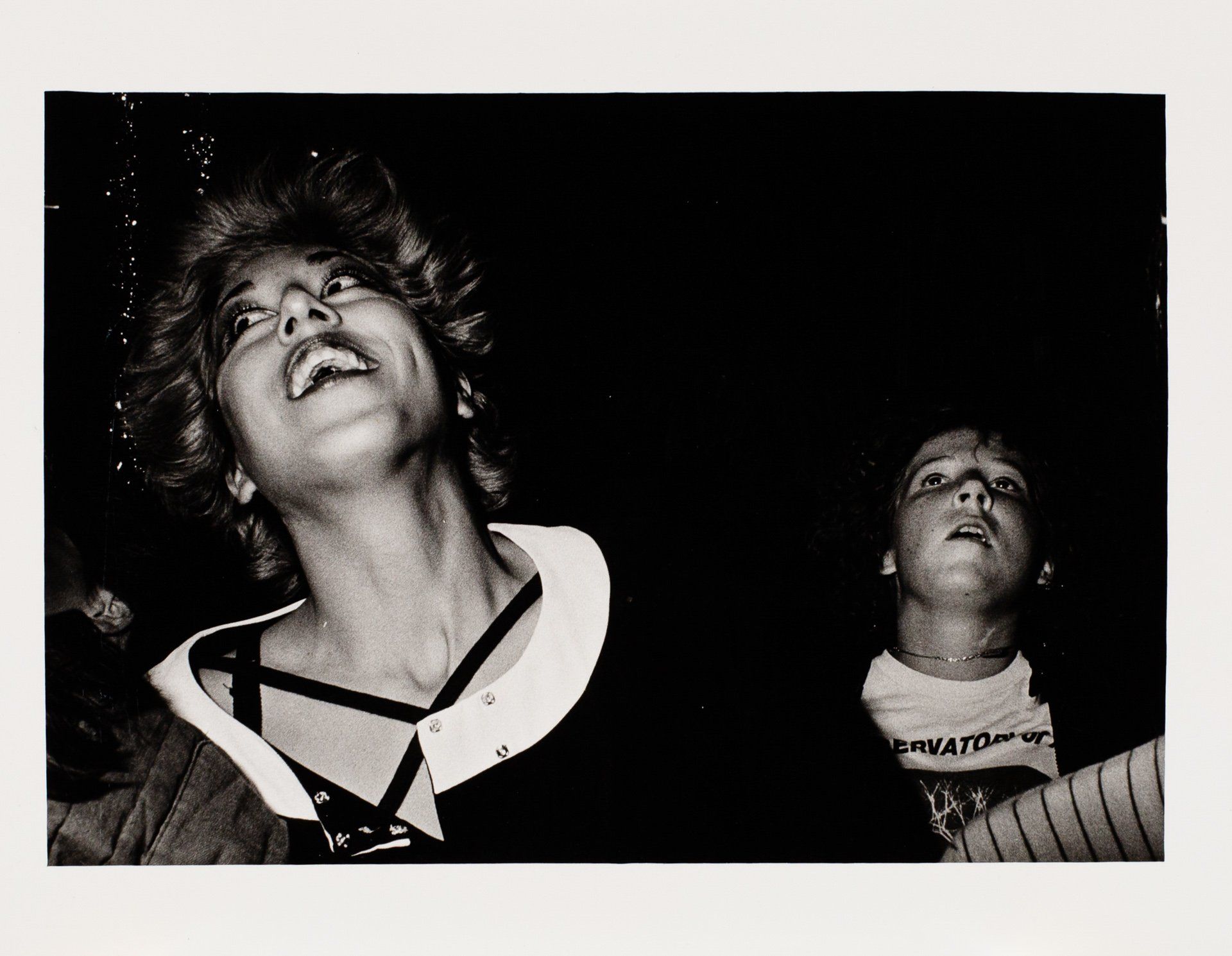 A black and white photo of two people looking up