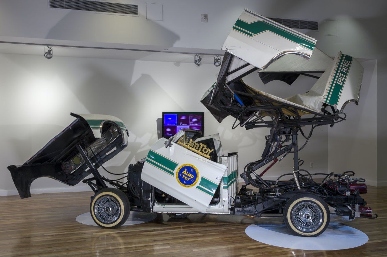 A white and green police car is sitting on a wooden floor.
