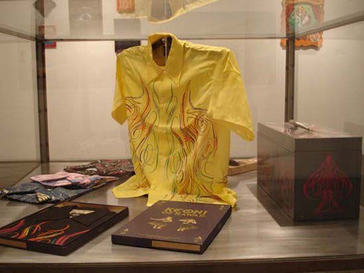 A yellow shirt is on display in a glass case