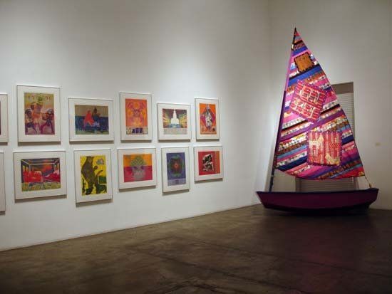 A room with a sailboat and paintings on the wall