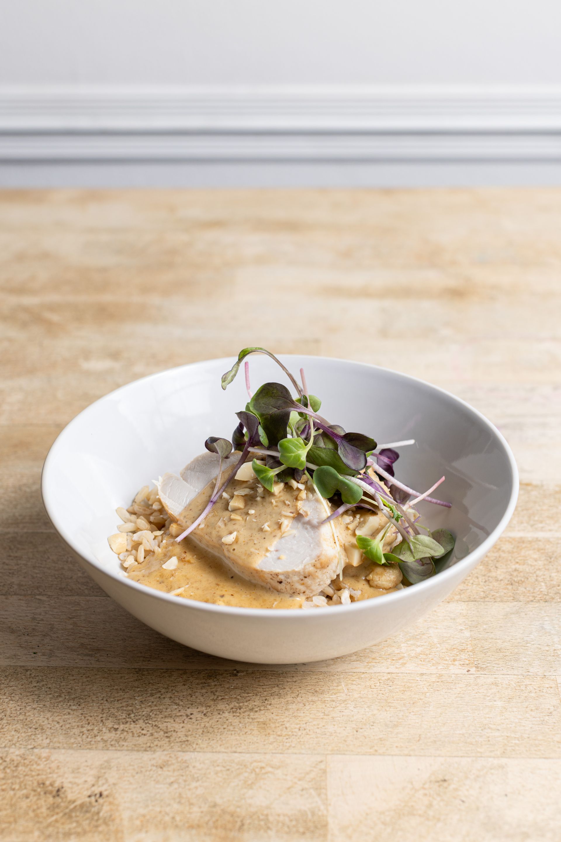 A bowl of food is sitting on a wooden table.