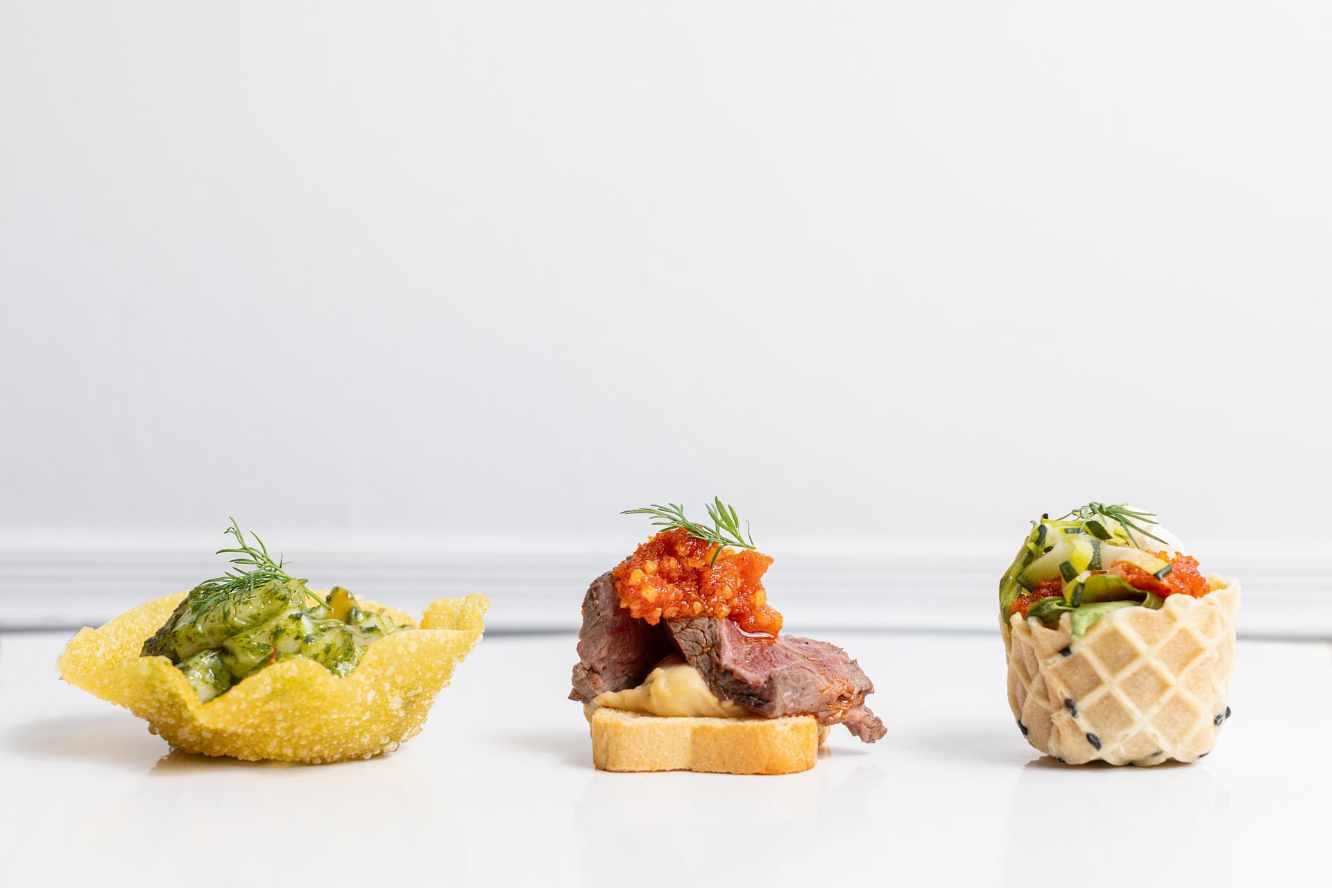 Three different types of food are sitting on a white table.