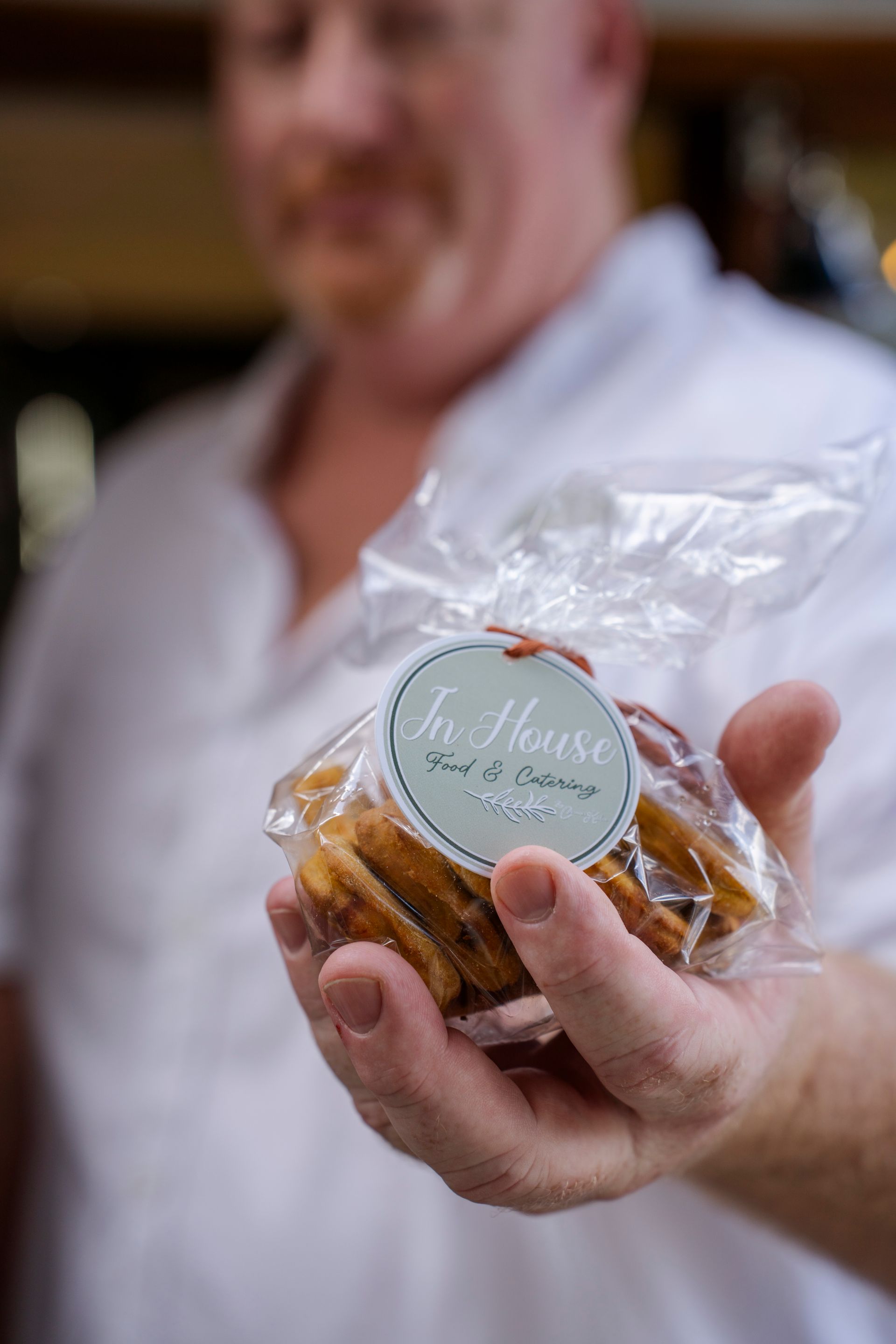 A man is holding a bag of cookies in his hand.