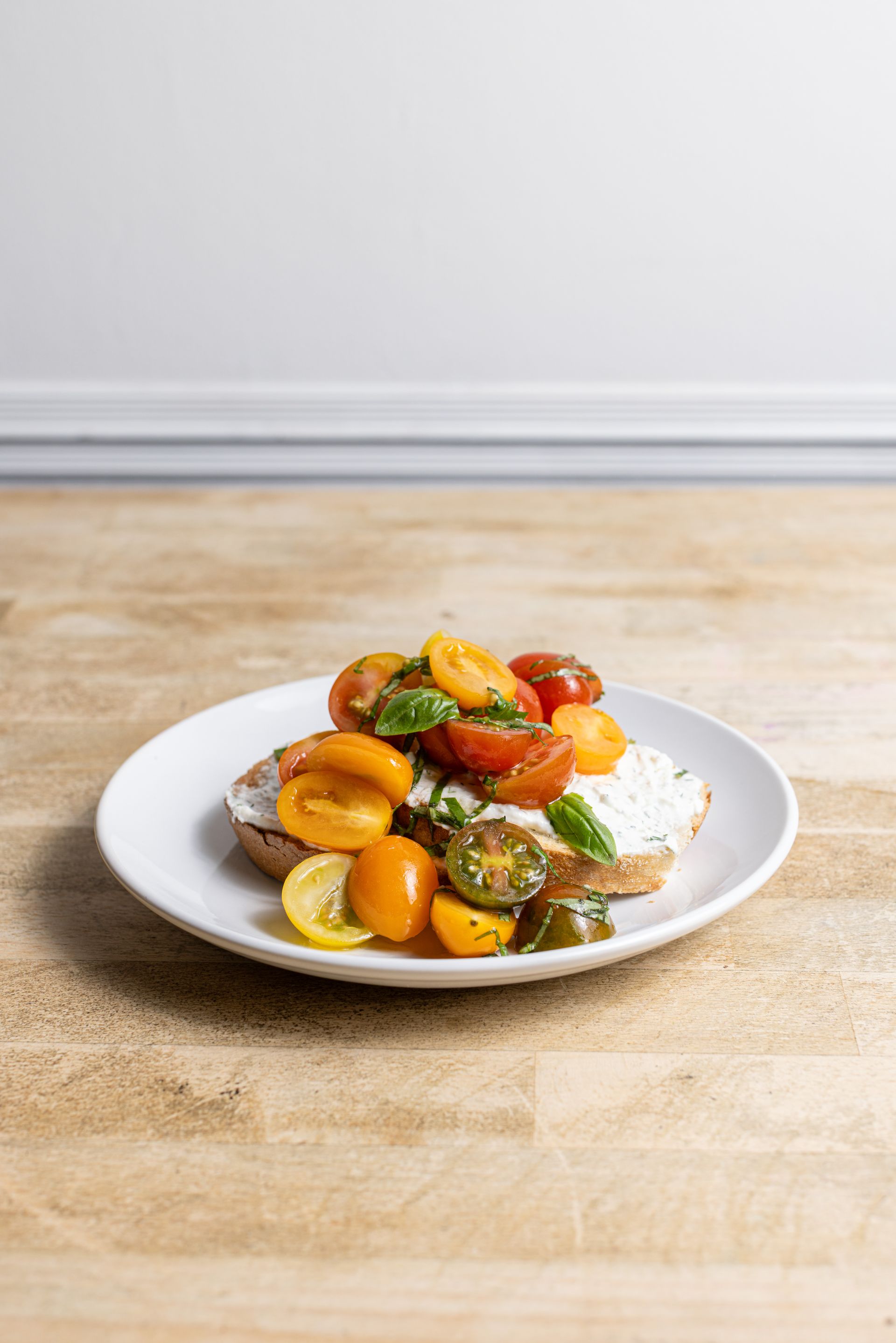 A plate of food with tomatoes and cheese on a wooden table.