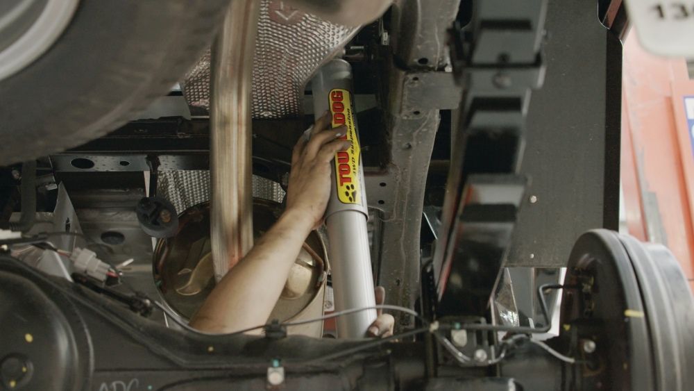 A Person Is Working On The Underside Of A Truck — Gympie Diesel & Dyno Centre in Glanmire, QLD