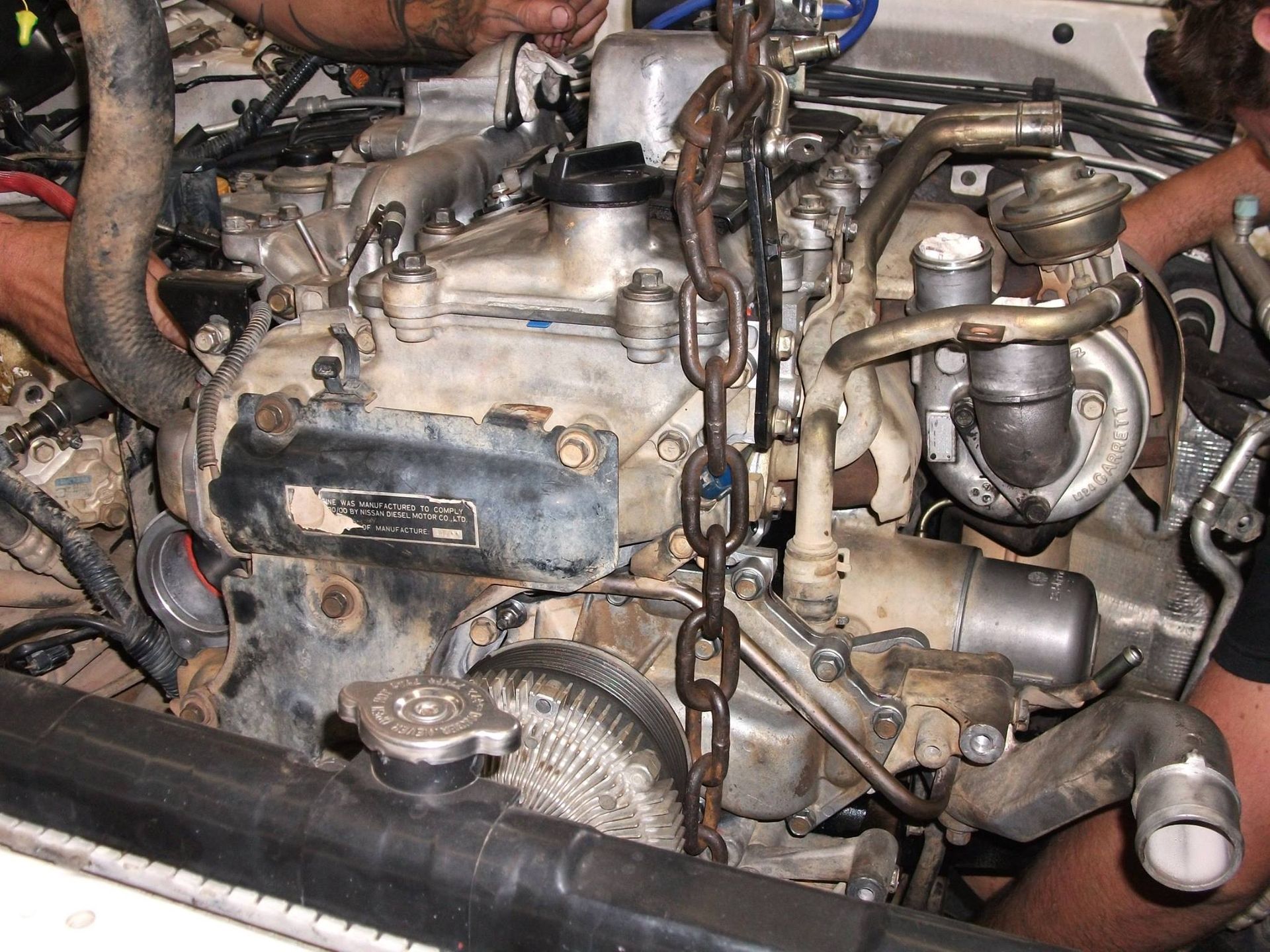 A Man Is Working On The Engine Of A Car — Gympie Diesel & Dyno Centre in Glanmire, QLD