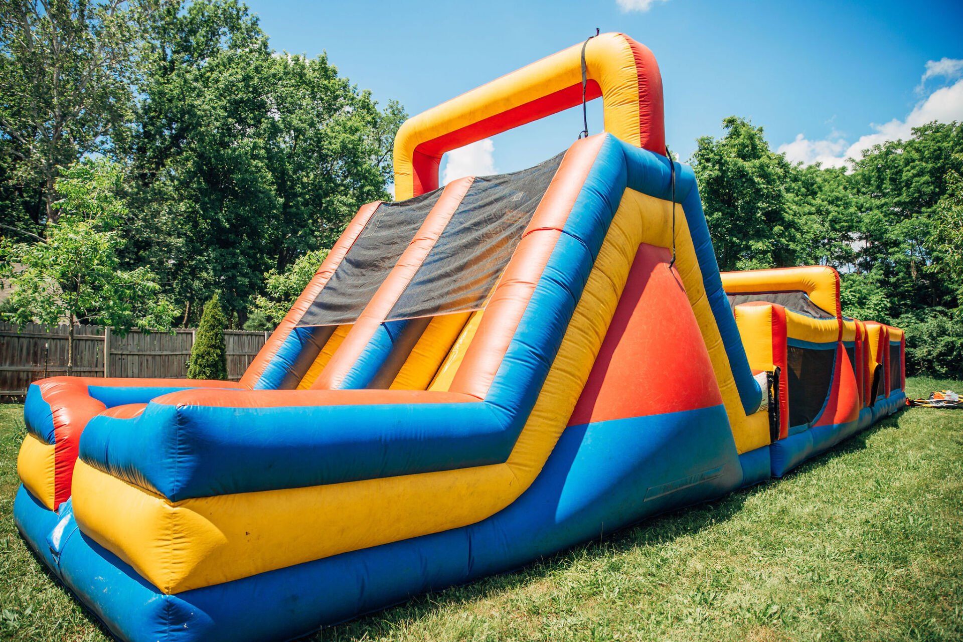 A large inflatable obstacle course is sitting on top of a lush green field.