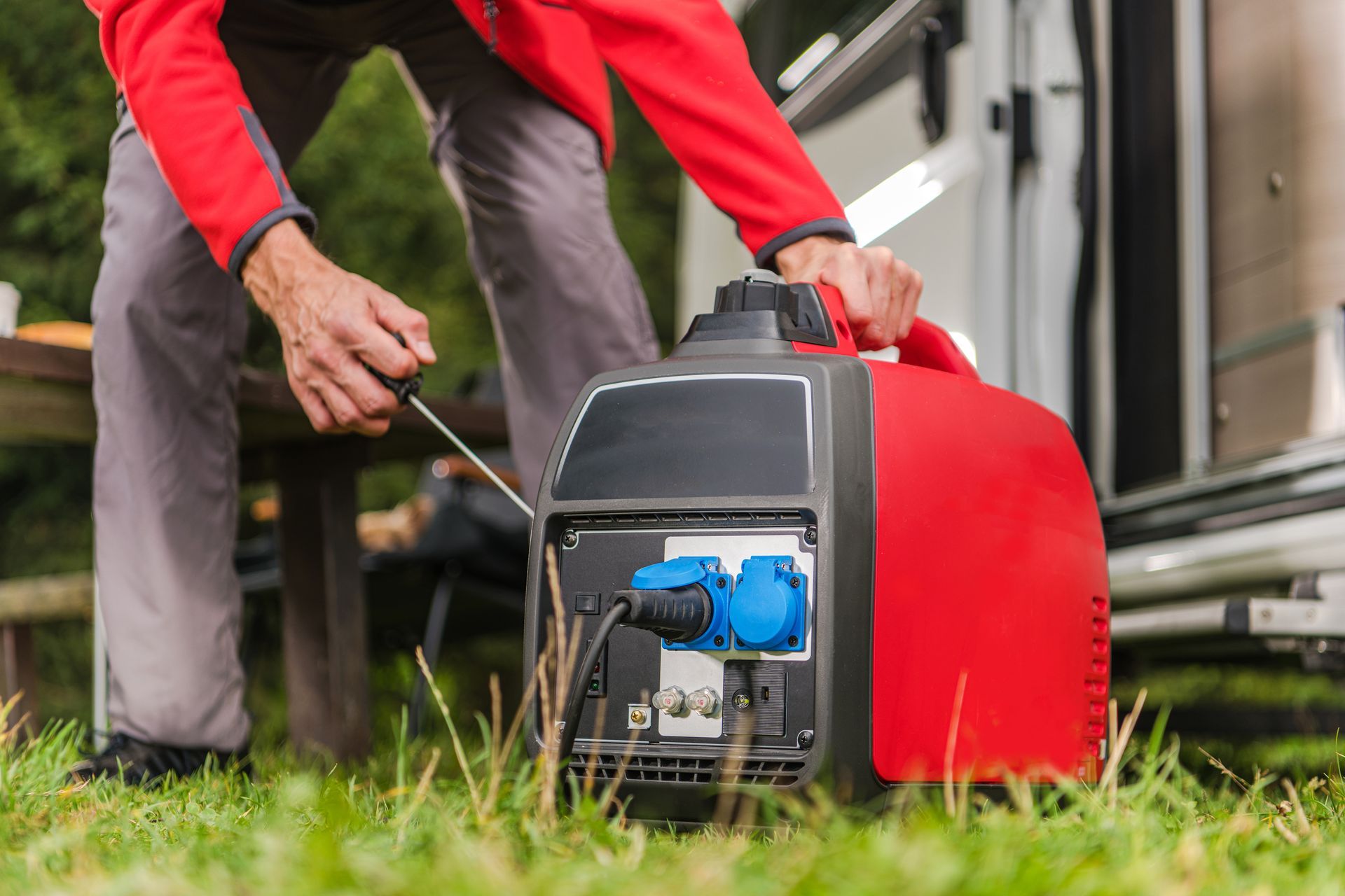 A man is plugging a generator into a rv.