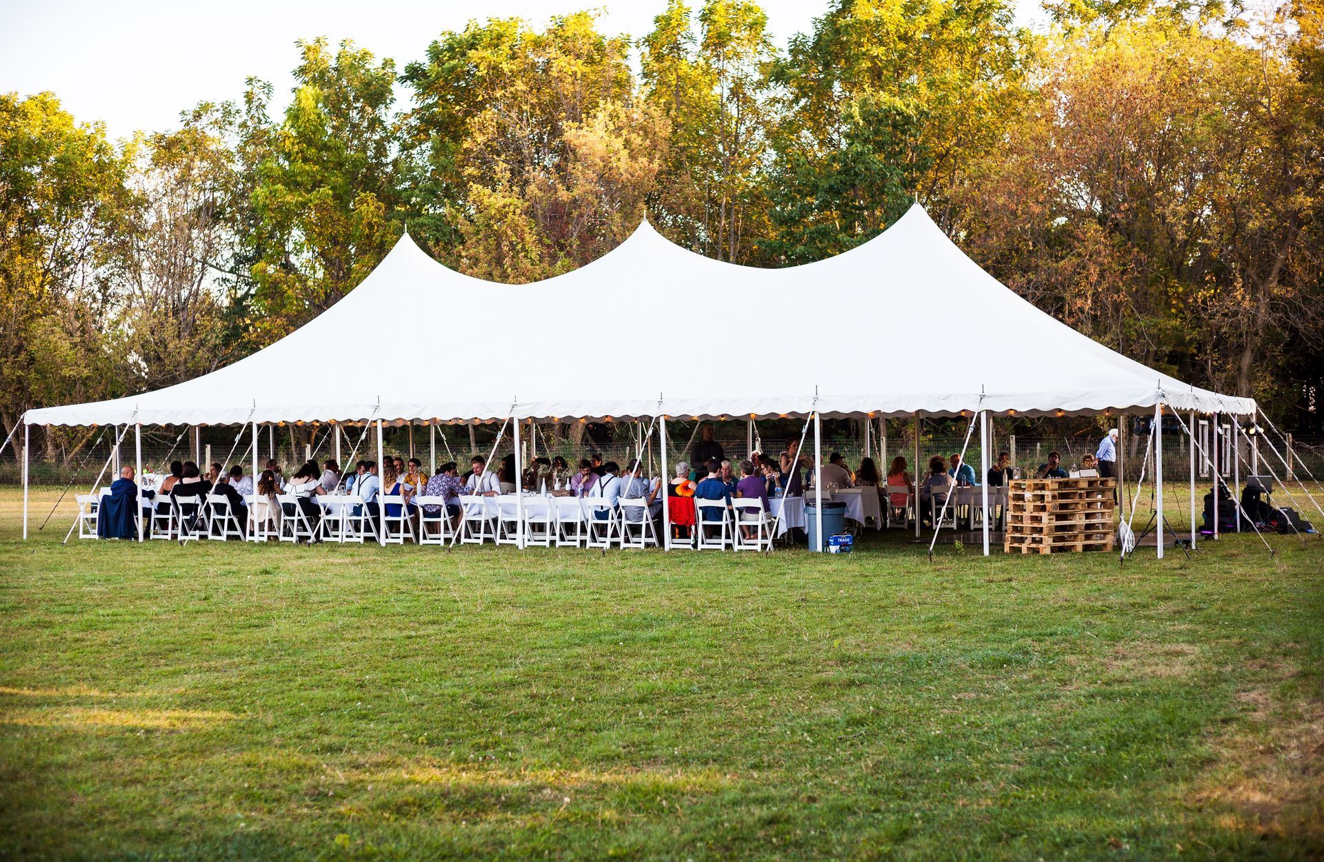 A large white tent is sitting in the middle of a grassy field.