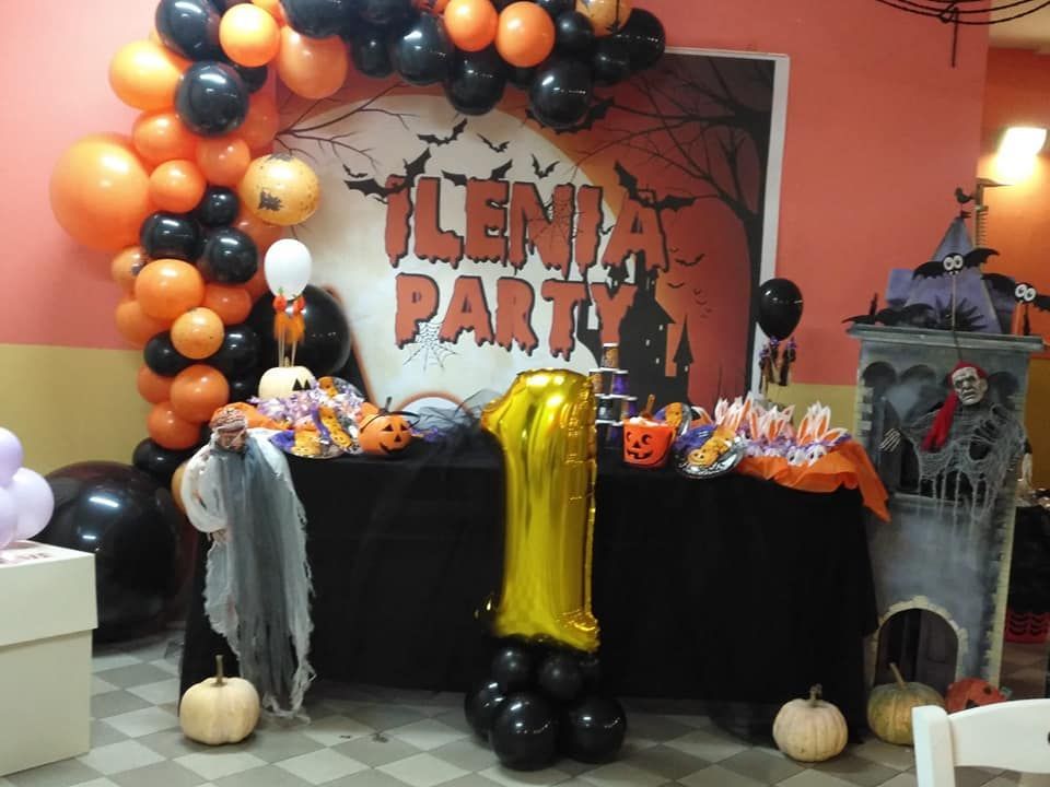 Un tavolo decorato per una festa di Halloween con palloncini e zucche