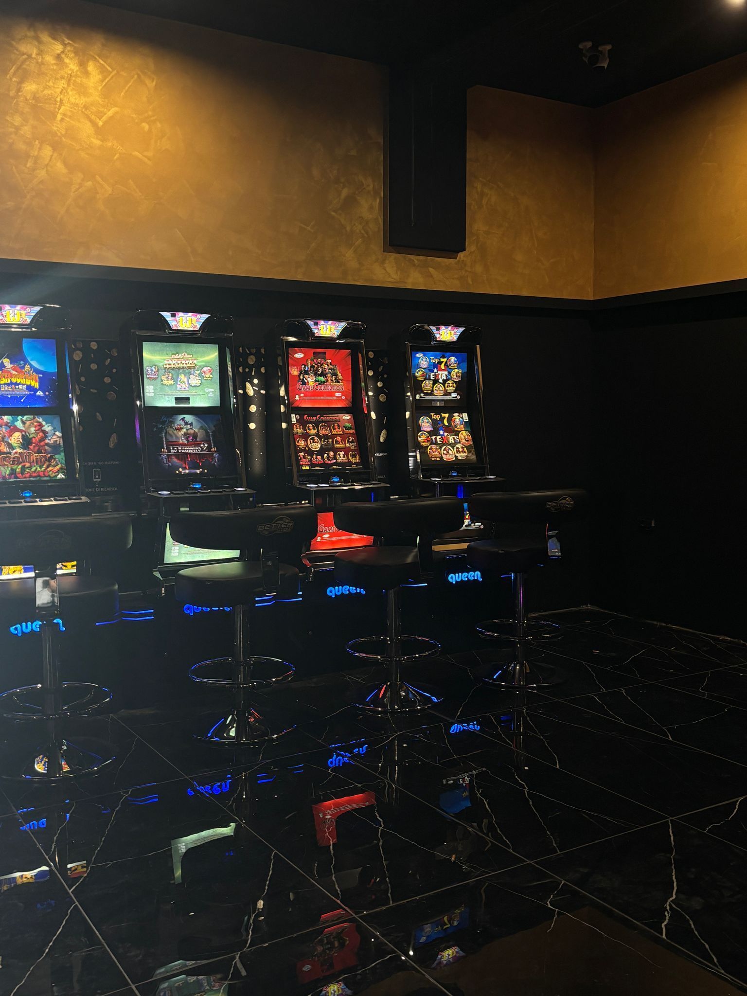 Una fila di slot machine in una stanza buia