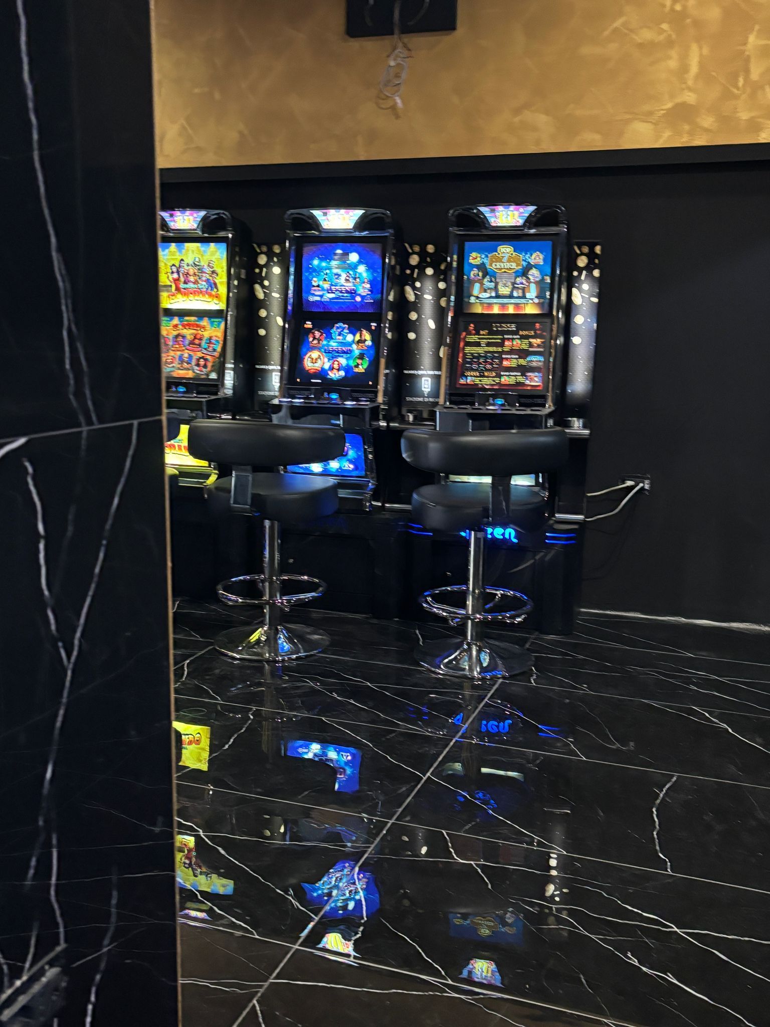 Una stanza con un sacco di slot machine e sedie