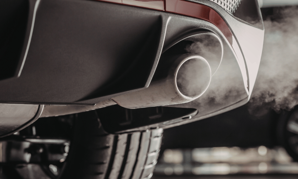 Car exhaust pipe releasing visible emissions from tailpipe
