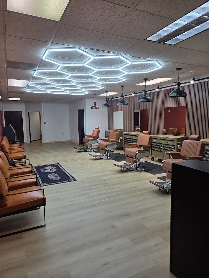 A barber uses thinning shears and a comb to trim a person's hair.