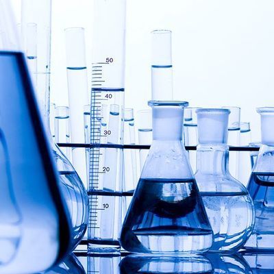 Blue laboratory glassware and beakers with liquid on a lab bench