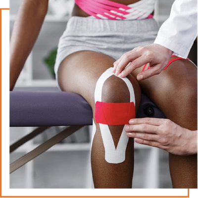 Knee taping on a seated patient’s leg during a physical therapy session