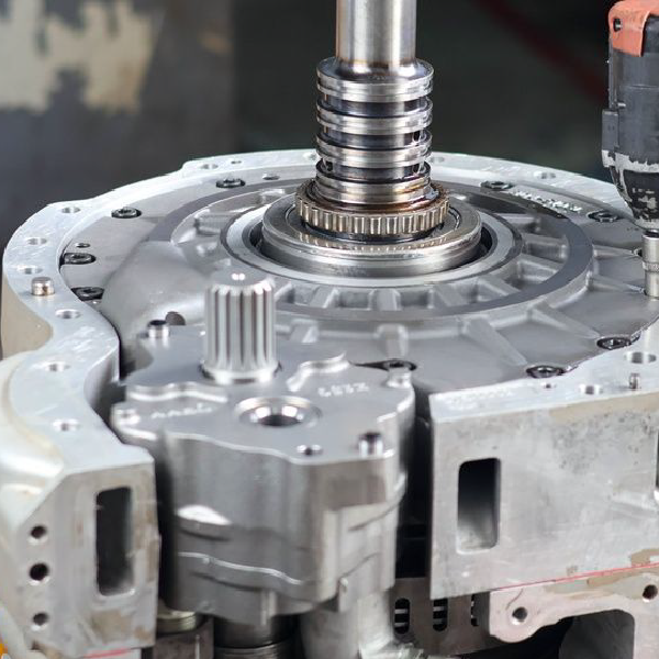 Metal gearbox or transmission housing with a central shaft in a workshop setting