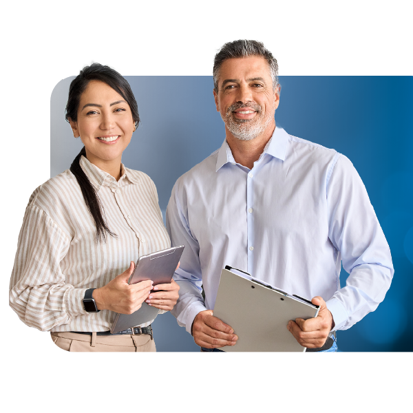 Two smiling coworkers holding clipboards against a blue studio backdrop