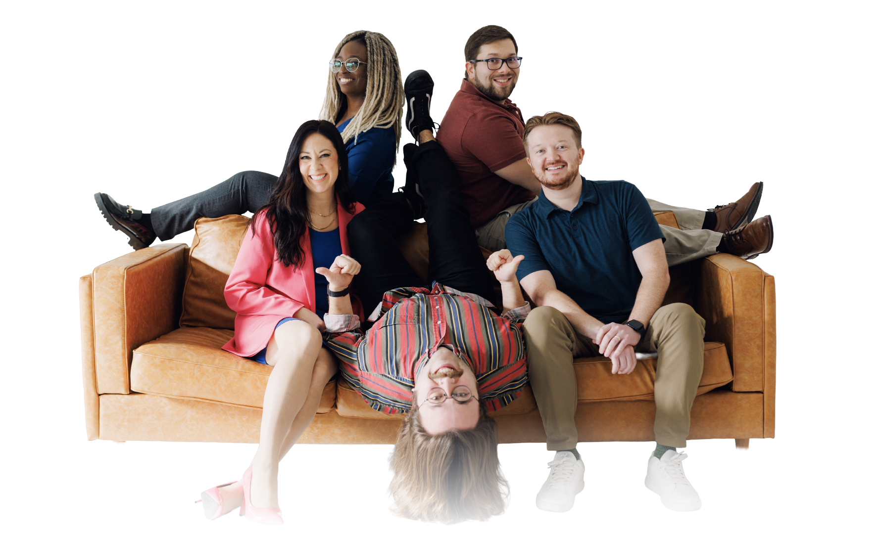 Five people lounging playfully on a tan couch, with one hanging upside down in front.