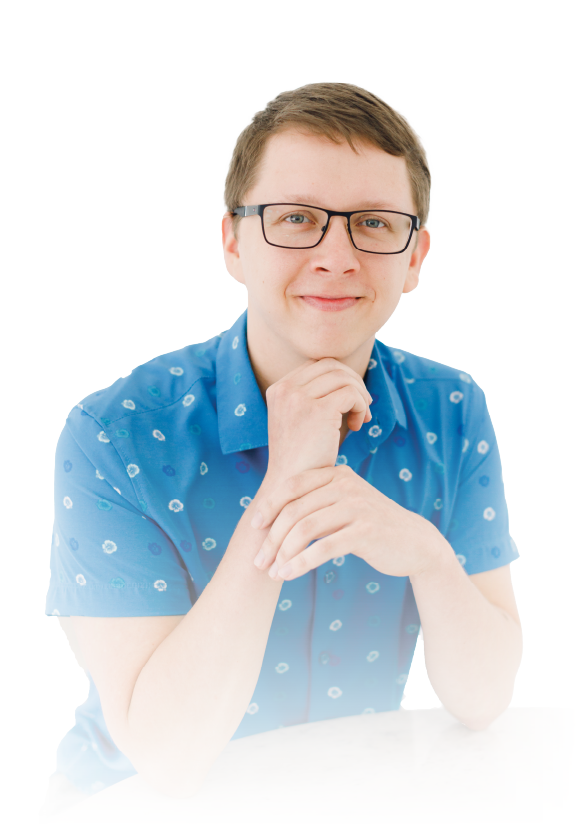 Person in a blue patterned shirt and glasses posing with hands under chin against a white background