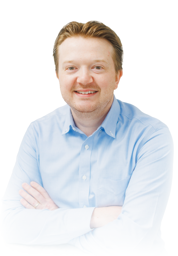 Smiling person in a light blue shirt with arms crossed against a white background