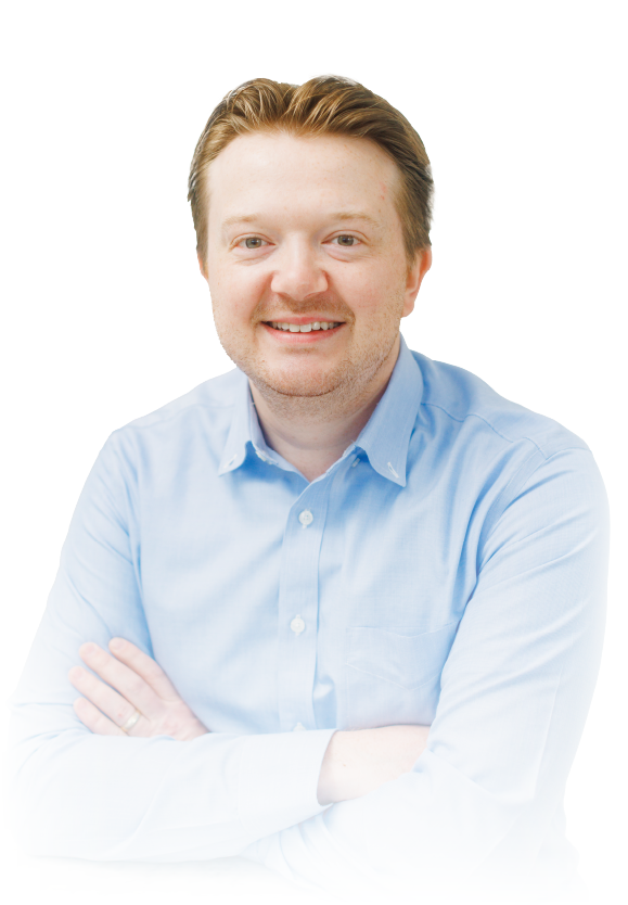 Smiling person in a light blue shirt with arms crossed against a white background