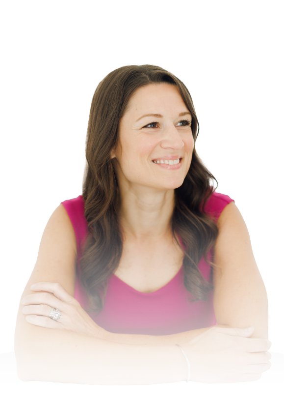 Smiling woman in a pink top with arms crossed against a white background