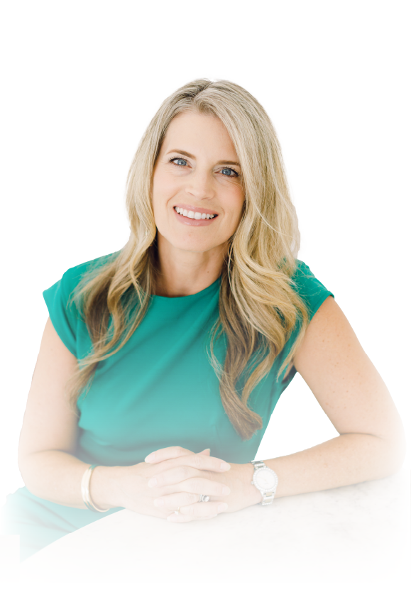 Smiling woman in a teal blouse with blonde hair, seated against a white background.