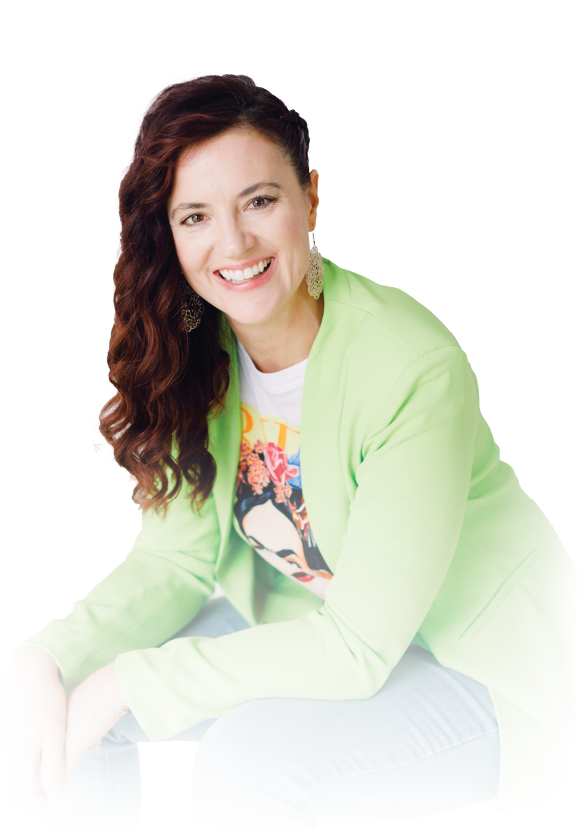 Smiling person seated on a white background, wearing a light green jacket and dark red hair.