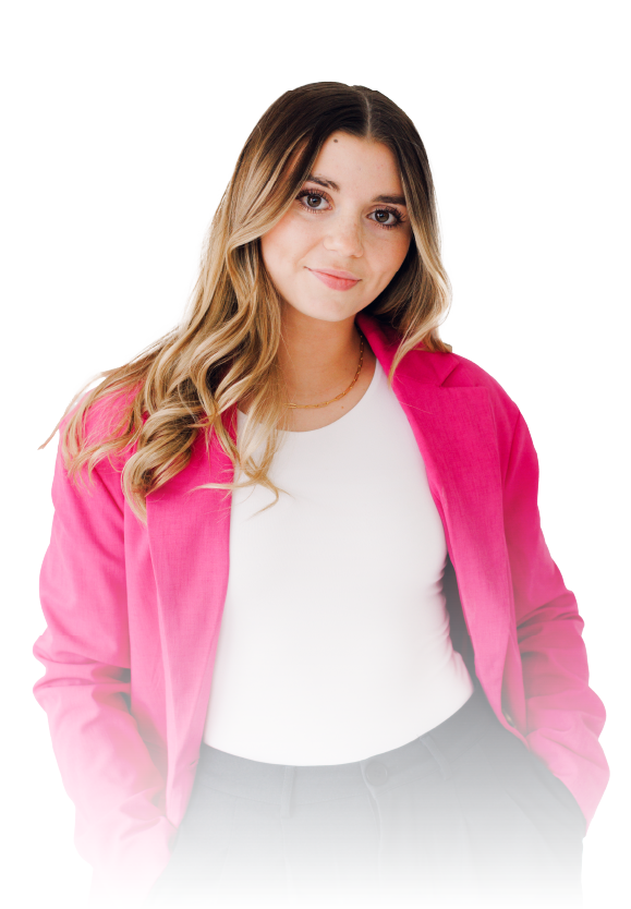 Woman in a bright pink jacket over a white top, standing against a white background and smiling gently