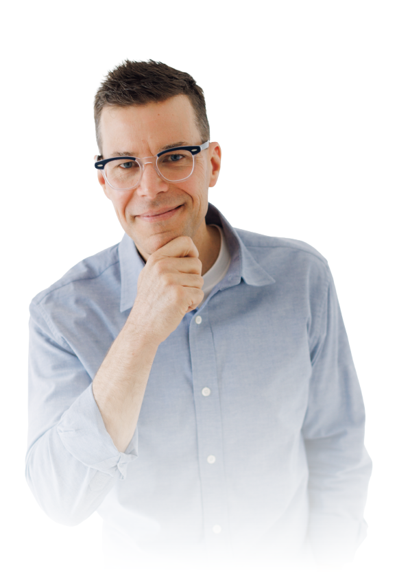 Man in glasses and light blue shirt smiling with hand on chin against a white background