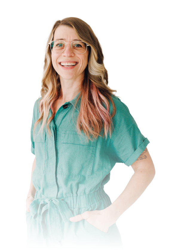 Smiling person in glasses wearing a teal shirt, standing against a white background