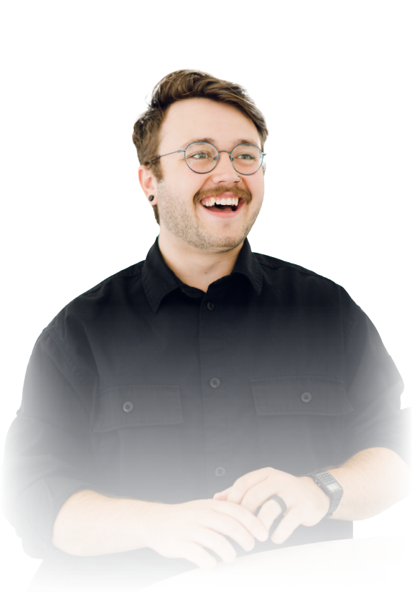 Smiling person in a black shirt and glasses, seated against a white background.