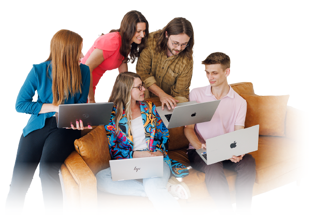 Group of people gathered on a couch, using laptops and discussing together in a bright setting