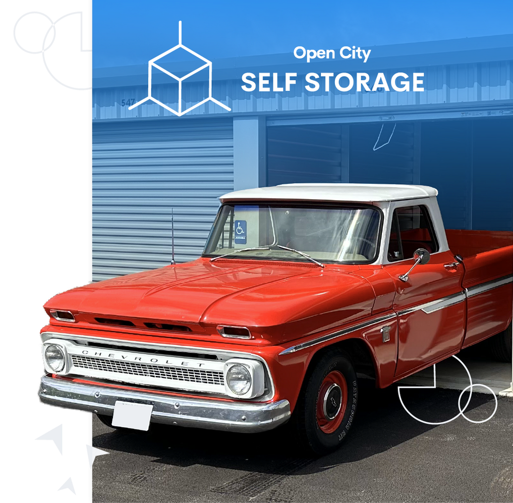 Red vintage pickup truck parked in front of an Open City Self Storage building.