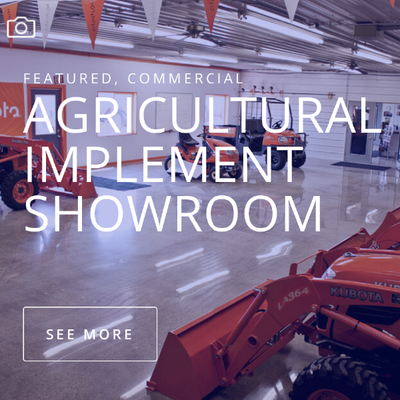 Agricultural implement showroom with red machinery in a warehouse-like display area