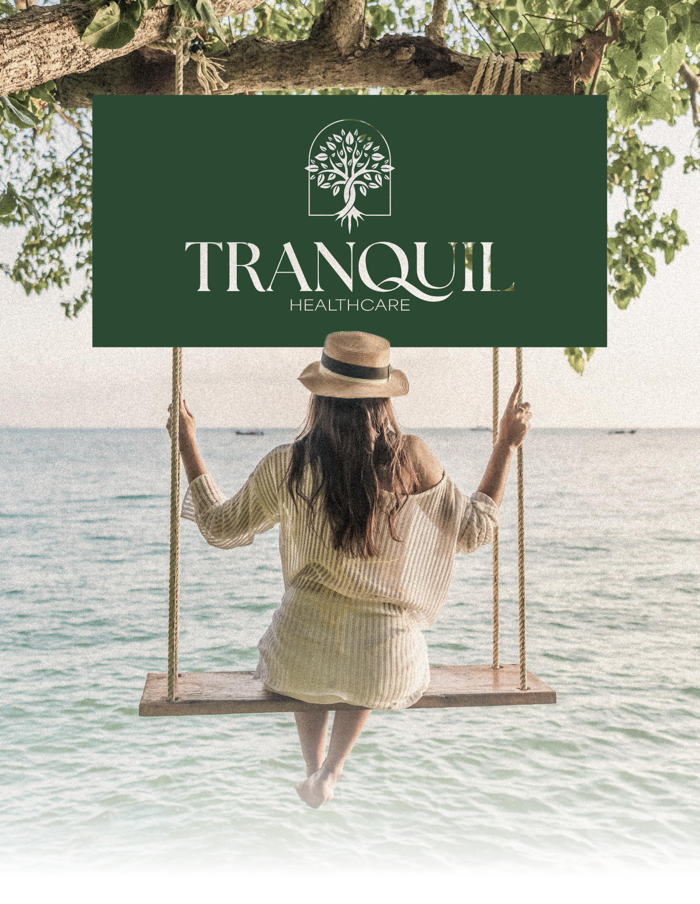 Woman on a beach swing beneath a green “TRANQUIL” sign, facing the ocean.