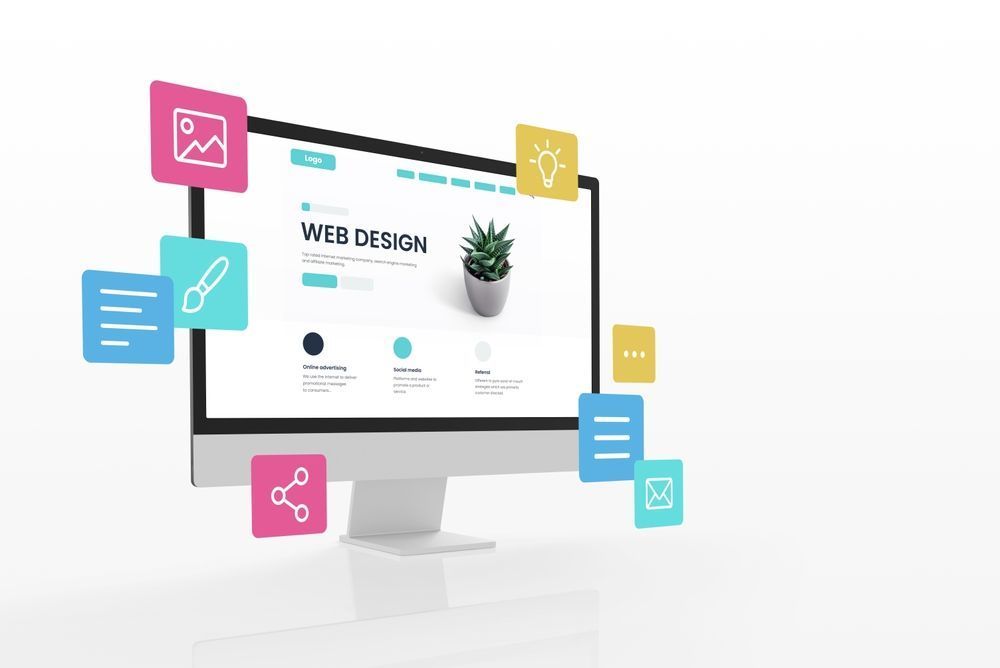 Web design mockup on a desktop monitor with colorful app icons floating around it