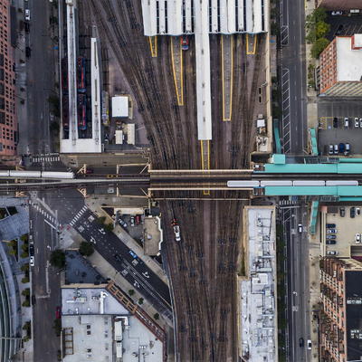 Aerial view of a train station with multiple tracks, platforms, and adjacent city streets.