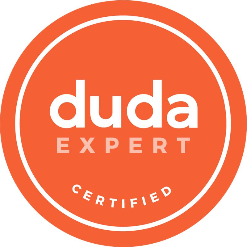 Orange circular Duda Expert Certified badge with white text and border