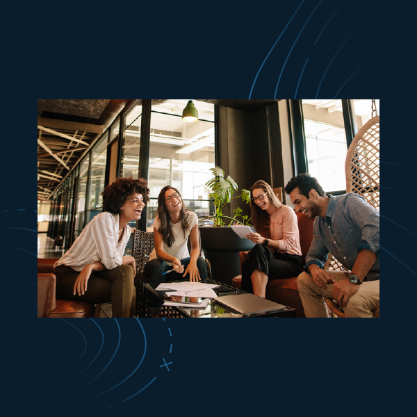 Group of coworkers chatting in a bright café lounge around a low table