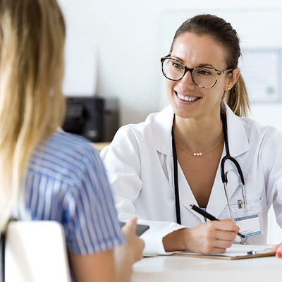 Doctor smiling and talking with a patient in a bright clinic office