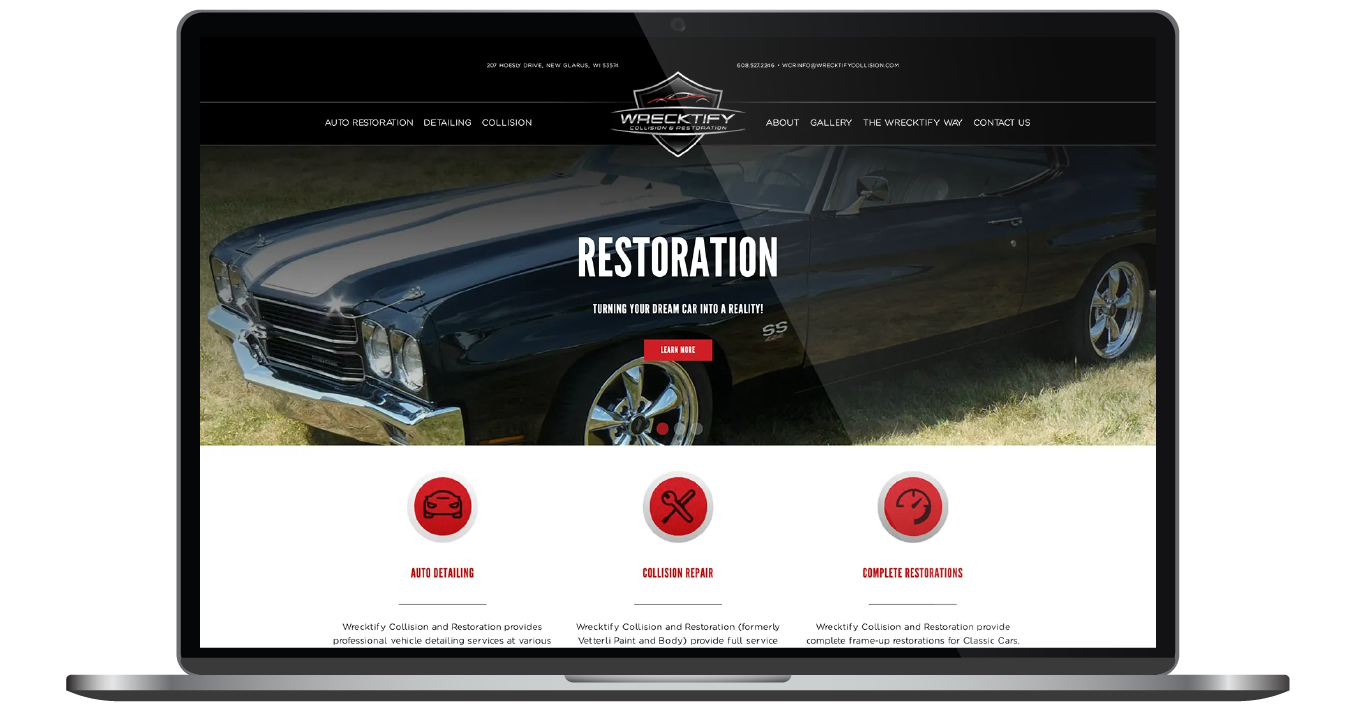 Laptop displaying a car restoration website with a dark classic car hero image and red service icons below