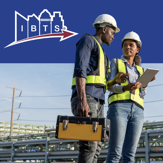 IBTS workers in hard hats and safety vests reviewing plans at an industrial site