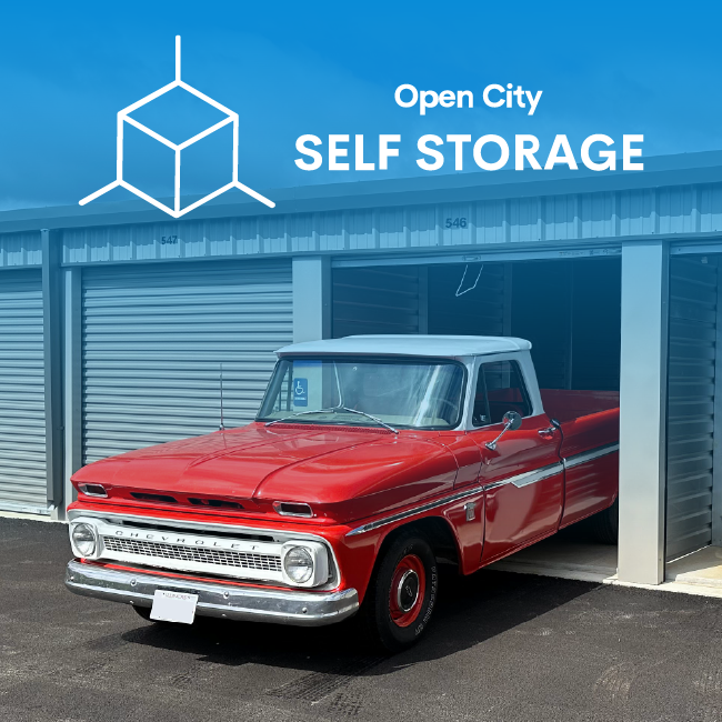Red vintage pickup truck parked outside Open City Self Storage unit