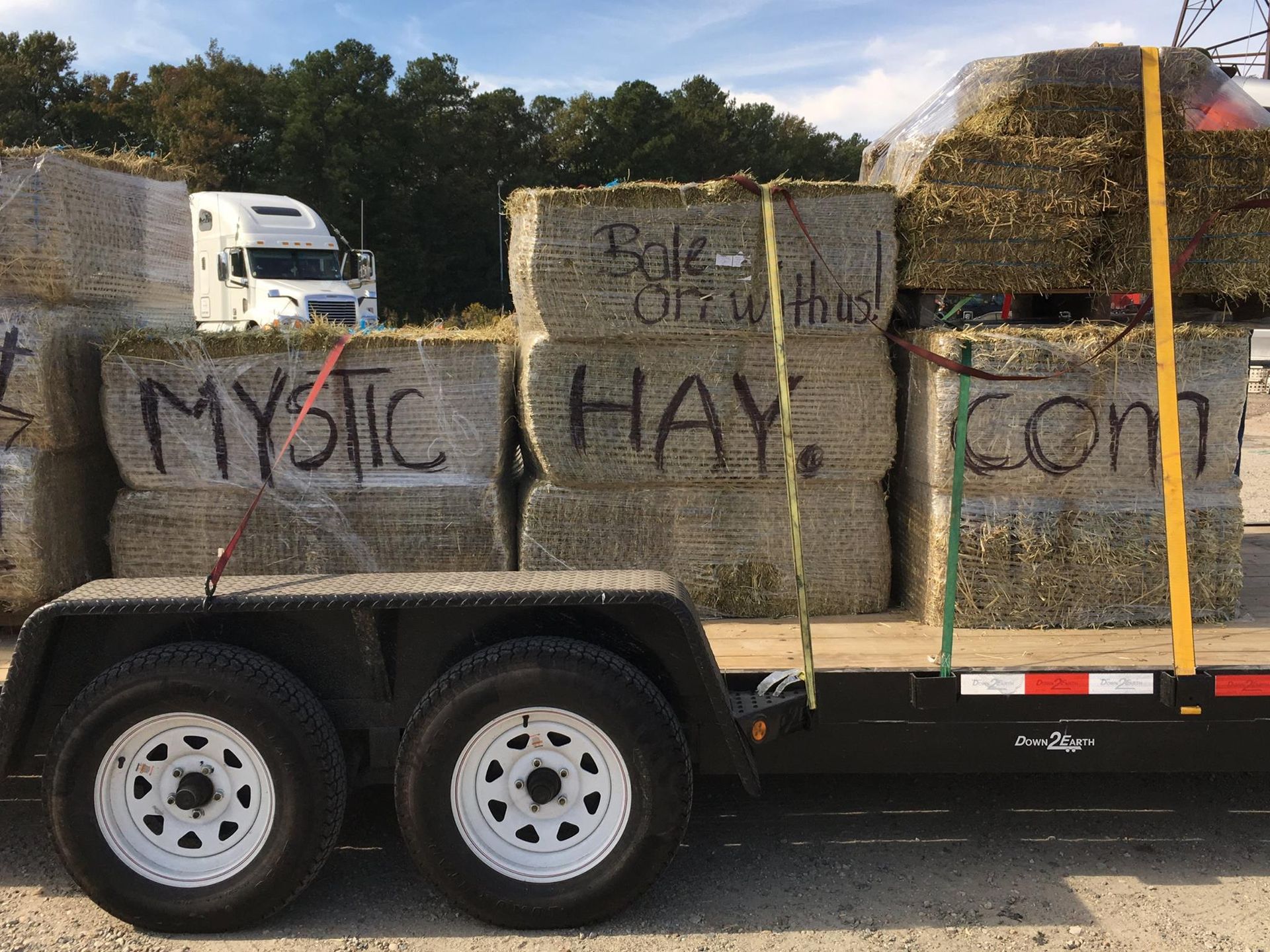 A trailer carrying hay bales, marked 