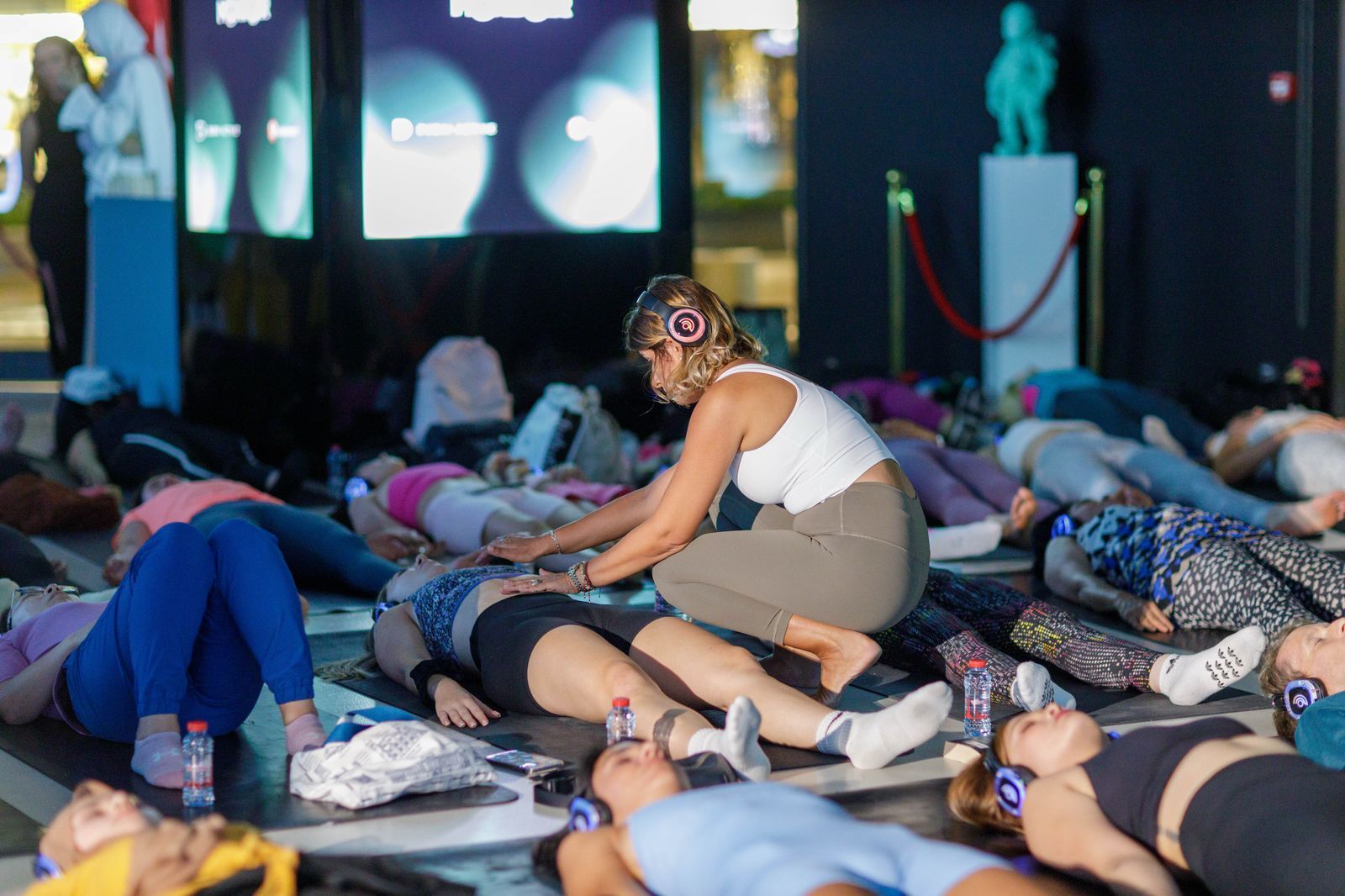 A woman is kneeling over a group of people laying on the floor.